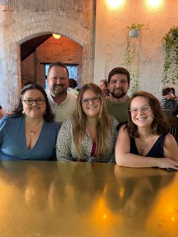 Ashley and family sitting at a table.